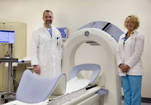 Cardiologist Dr. James Mohn and CNMT Lead Nuclear Medicine Technologist Caroline Edland stand by the Discovery™ NM 530 nuclear imaging system